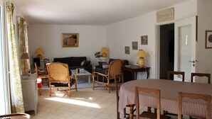 A living room with a sofa, chairs, a dining table, and lamps. - House CARNAC - 300 meters from Légenèse beach (Carnac)