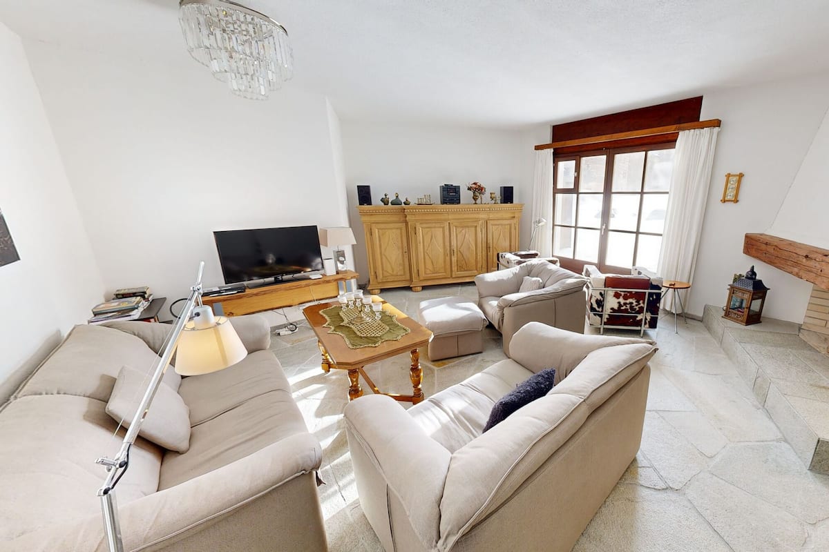 A living room with a sofa, coffee table, TV, and fireplace.