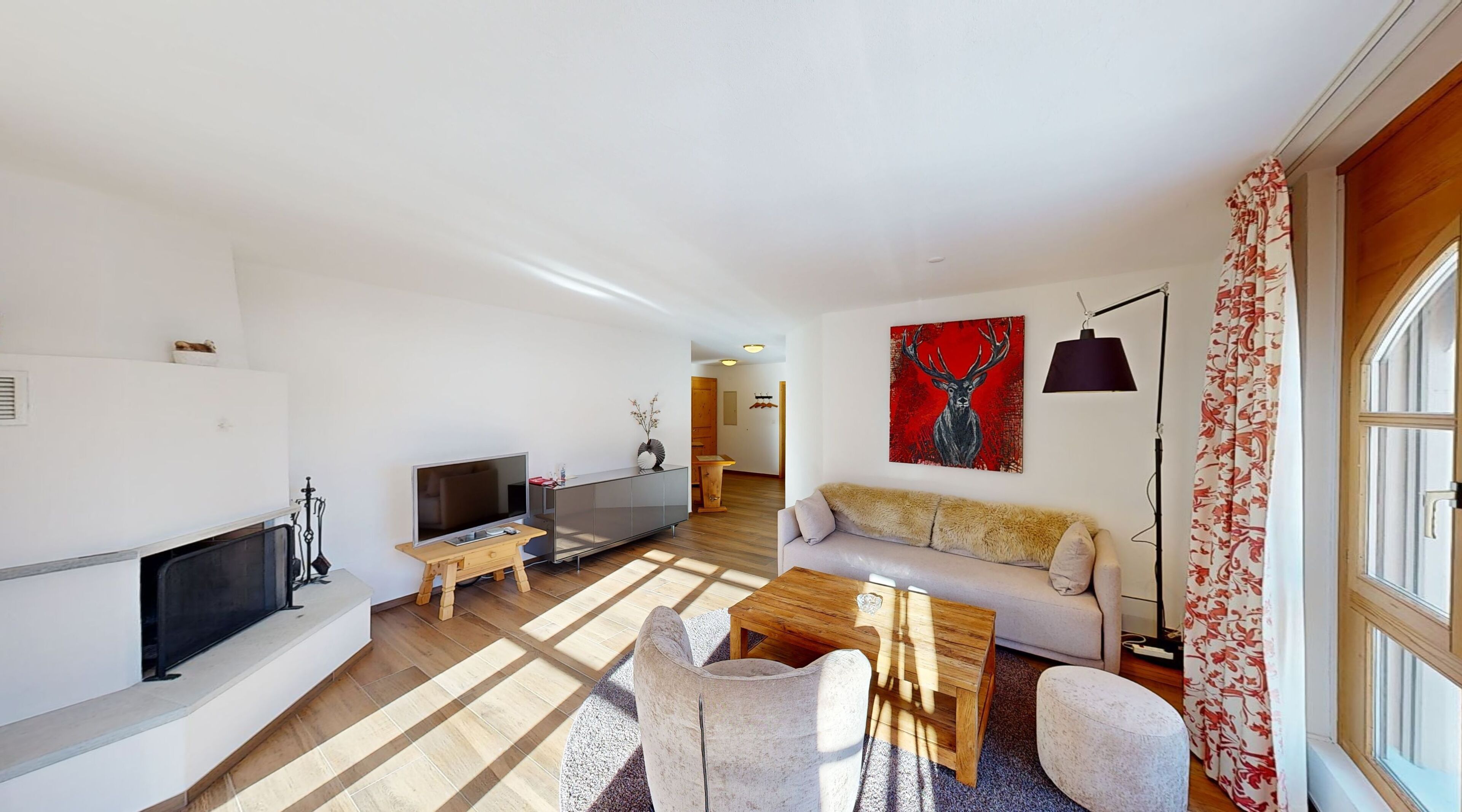 Ein modernes Wohnzimmer mit Fernseher, Sofa und Couchtisch aus Holz.