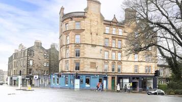 A historic building with multiple stories, featuring a corner entrance and a mix of architectural styles.