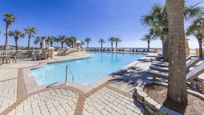 A swimming pool with lounge chairs and palm trees. - La Madeleine Coastal Home Resort Pools Quiet Beach (Gulf Shores)