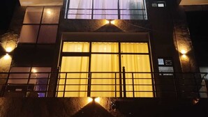 A multi-story building with illuminated windows and a balcony. - Kalindi Vihar  (Mathura)