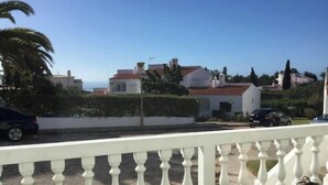 Un barrio residencial con casas blancas, una valla blanca y un cielo azul despejado.