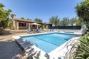 A swimming pool with lounge chairs, a covered seating area, and a stone building in the background. - PUIG PETIT. Delightful villa ideal for couples or small groups (Pollensa)