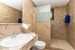 Bathroom features a sink, toilet, and glass-enclosed shower area.