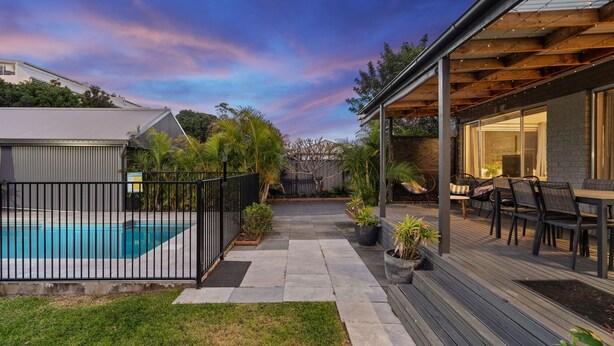 Un jardin avec une piscine, une terrasse dotée de mobilier d’extérieur et un espace abrité avec une table et des chaises.
