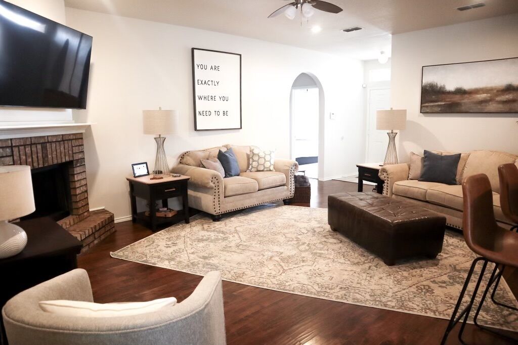 A living room with a fireplace, two sofas, a coffee table, and a TV.