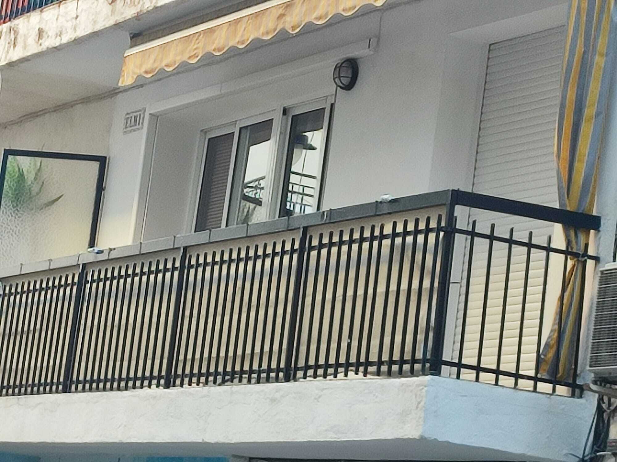A building with a balcony, a window, and a door.