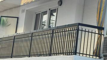 A building with a balcony, a window, and a door.