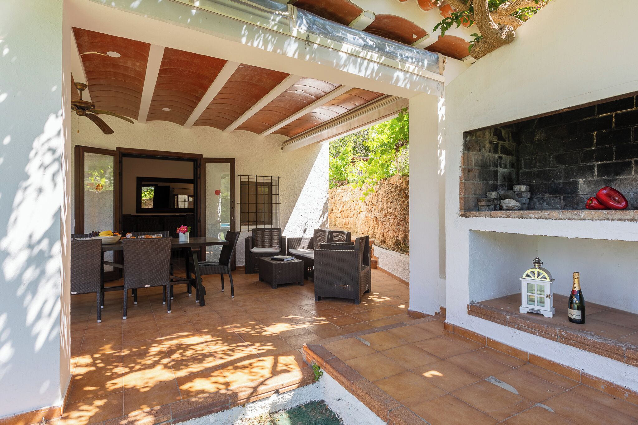 An outdoor patio with a dining area, seating, and a built-in grill.