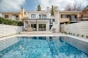 A modern villa with a swimming pool, a covered patio, and a view of neighboring houses. - Magnus Villa - Three Bedroom Villa, Sleeps 6 (Tala)