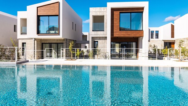 A modern hotel with a swimming pool, featuring contemporary architecture and a clear blue sky. - Avalon Gardens Villa 21 (Emba)