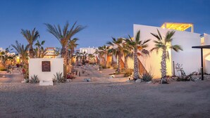 A modern resort with a desert garden, palm trees, and a central pathway leading to a building with a sign reading "CAI". - Sunny Bungalow with a Pool and Near the Beach (El Pescadero)