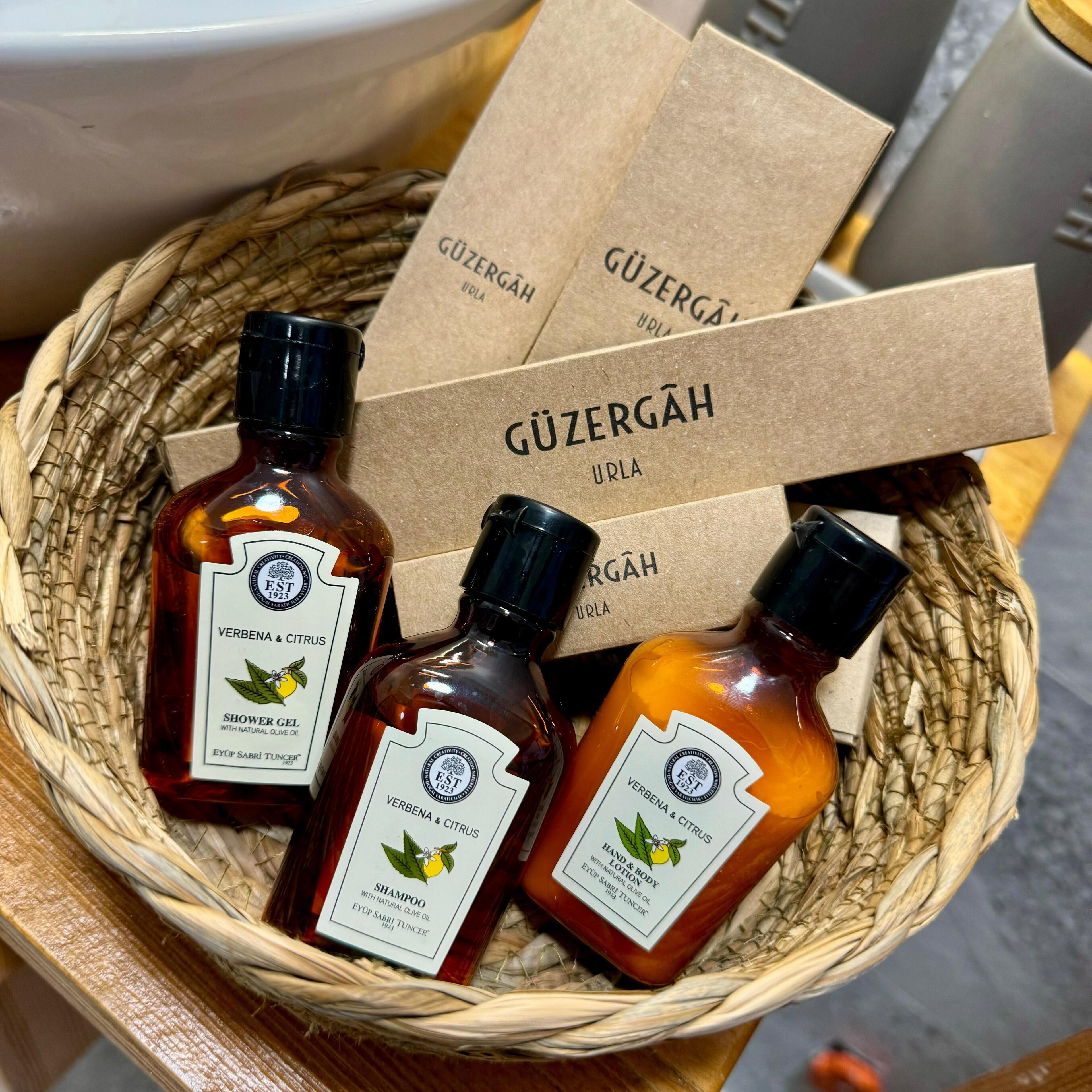 A basket containing three bottles of hand and body lotion with natural olive oil, labeled 'Verbenä & Citrus' and 'Eyüp Sabri Tuncer'.