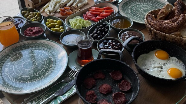 A breakfast table with various dishes, a pool view, and a glass table. - Güzergah Urla (Urla)