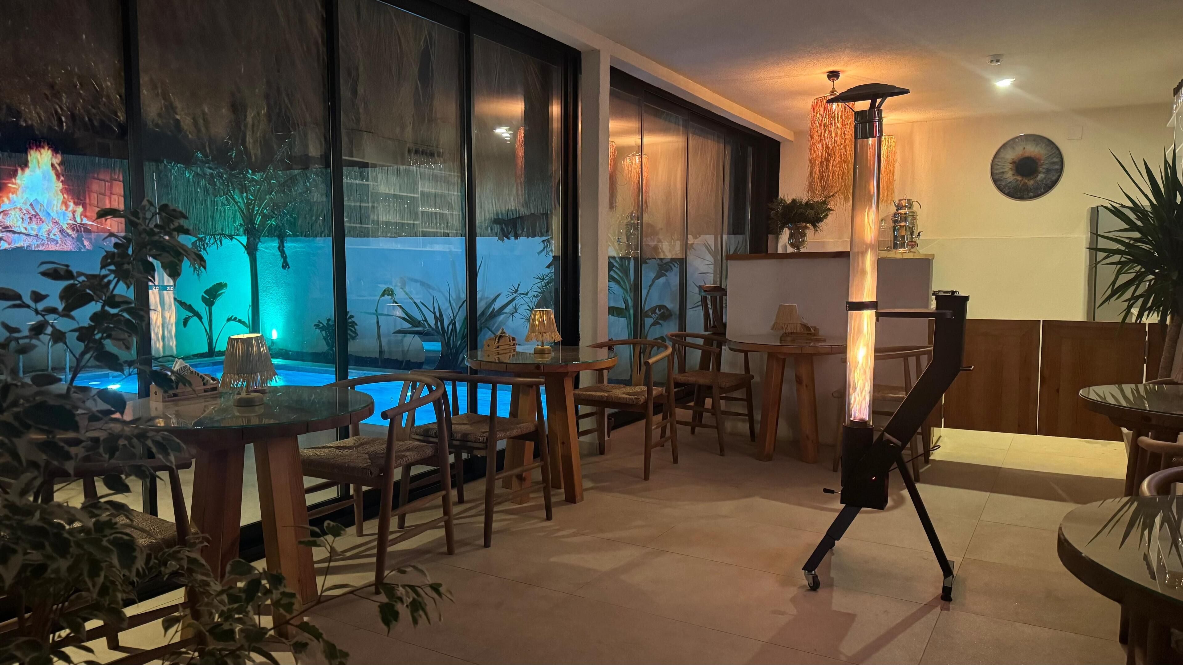 A cozy indoor setting with a pool, wooden furniture, and a unique hanging light fixture.
