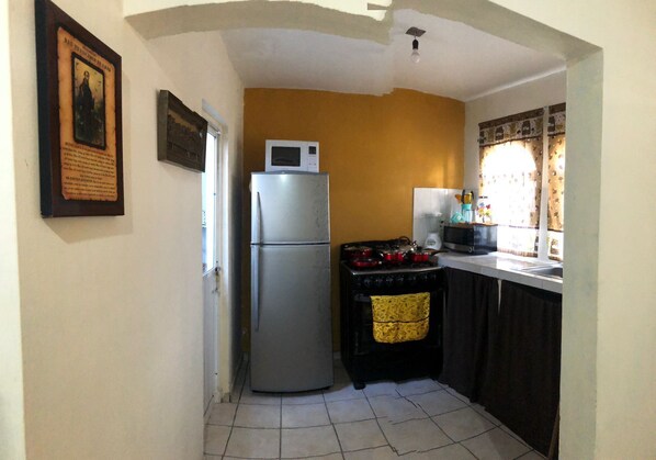 A compact kitchen with a refrigerator, stove, microwave, and sink. - Jhon House for 6 people (Tepic)