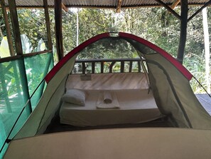 Una tienda de campaña con zona de dormir, incluyendo un colchón y almohadas.