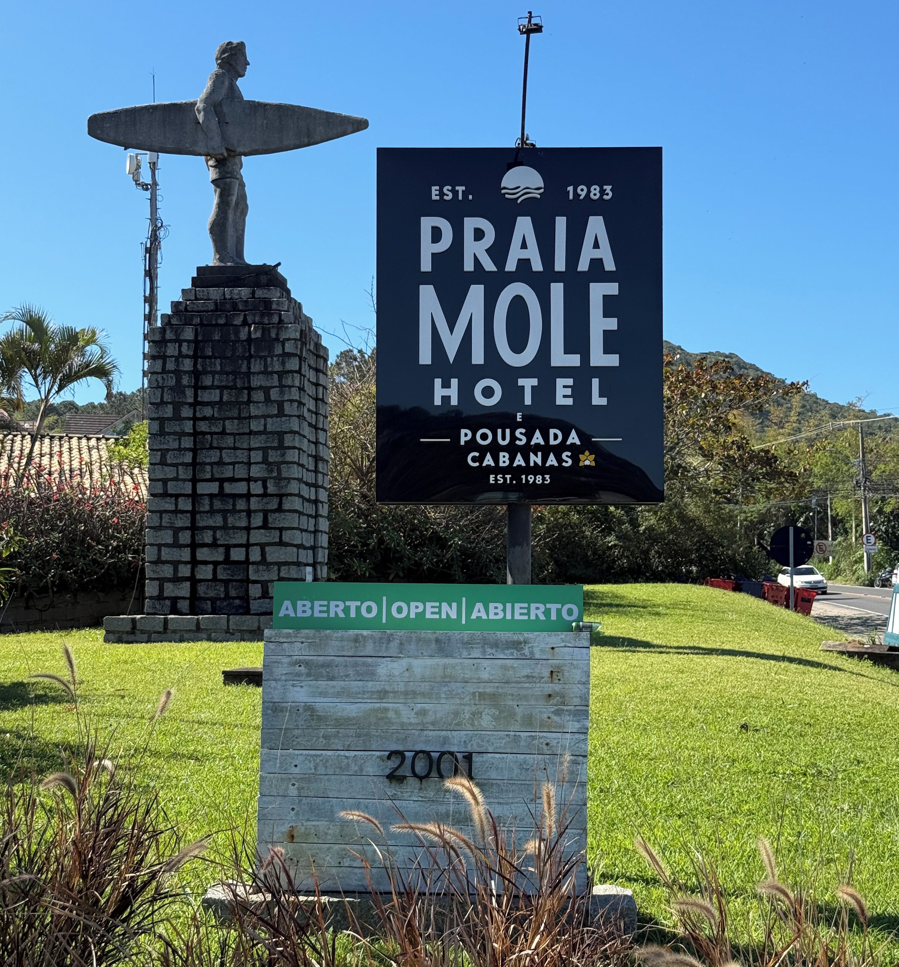 Naamplaatje voor Hotel Praia Mole, met een standbeeld op de achtergrond.
