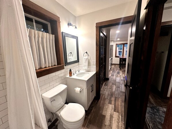 Un baño con inodoro, lavamanos y espejo.