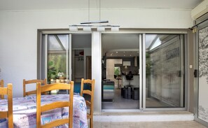Enjoy meals in the dining area with a wooden table and chairs, adjacent to a fully equipped kitchen.