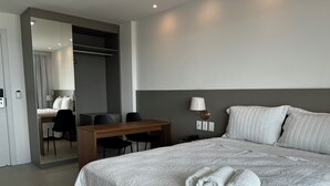 Ένα δωμάτιο ξενοδοχείου με ένα κρεβάτι, ένα γραφείο και μια καρέκλα.