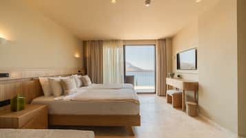 Une chambre d’hôtel avec un grand lit, une télévision, un balcon avec vue et une tête de lit en bois.