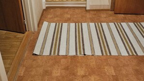 Un escalier recouvert de moquette, avec un tapis à rayures au bas.