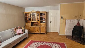 Un salon comprenant un canapé, un meuble en bois, une cheminée et un tapis à motifs.