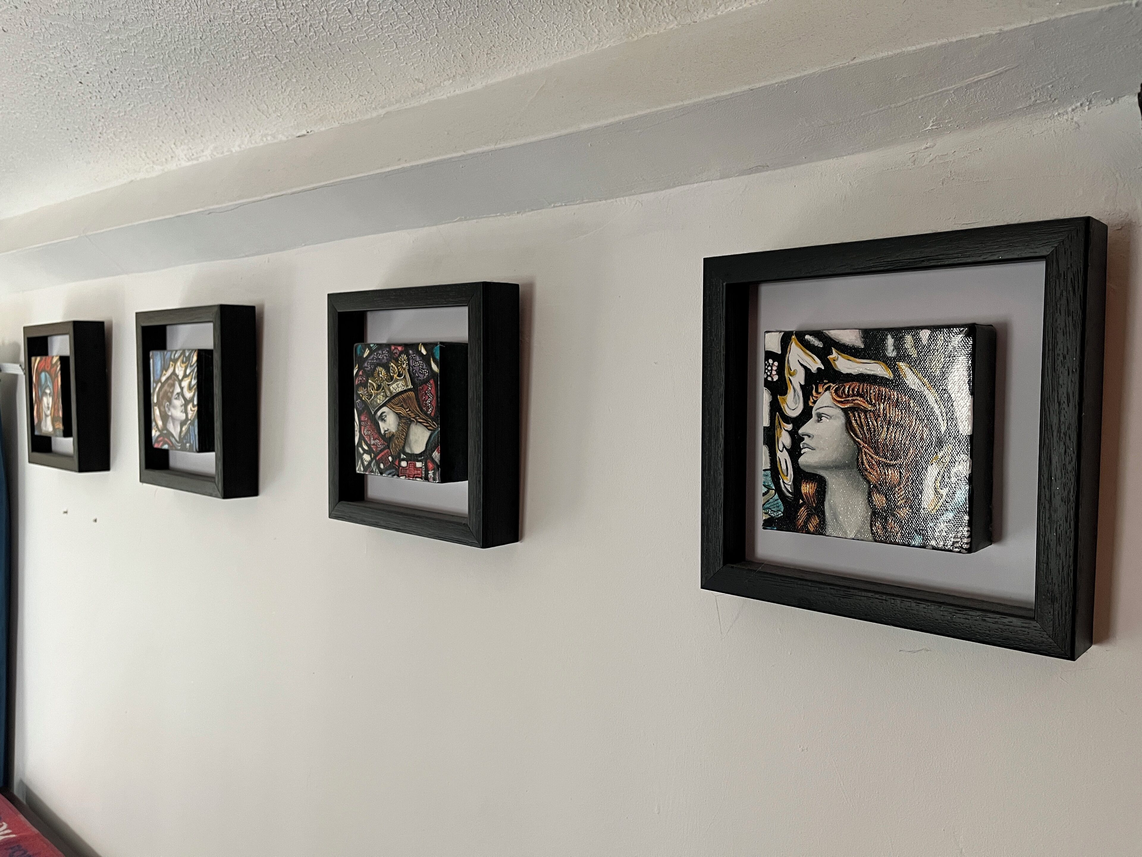 Un mur orné de quatre œuvres d’art encadrées.
