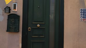 Eine grüne Tür mit Klingelschild, Briefkasten und einer Hinweisschild.
