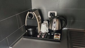 Eine moderne Küche mit integriertem Kaffeeautomaten, Wasserkocher und einer kleinen Arbeitsfläche.