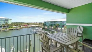 Een balkon met uitzicht op een jachthaven en gebouwen.