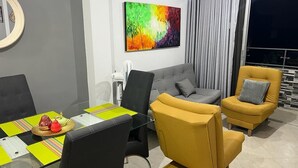 A modern living room with a glass table, two sofas, and a colorful abstract painting on the wall. - AMOBLADO LOS MOLINOS (Medellín)