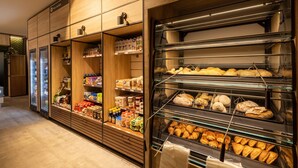 A bakery display with various baked goods and a refrigerated section with beverages. - Chalet With a Dishwasher, in a Car-free Park (Vlierden)