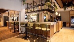 A modern bar area with wooden flooring, bar stools, and a counter with a variety of bottles. - Chalet With a Dishwasher, in a Car-free Park (Vlierden)