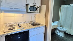 A compact kitchen with a built-in microwave, a dishwasher, and a sink. - Live In Lodge (Marietta)