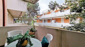 Un balcone con tavolo, sedie e piante in vaso.
