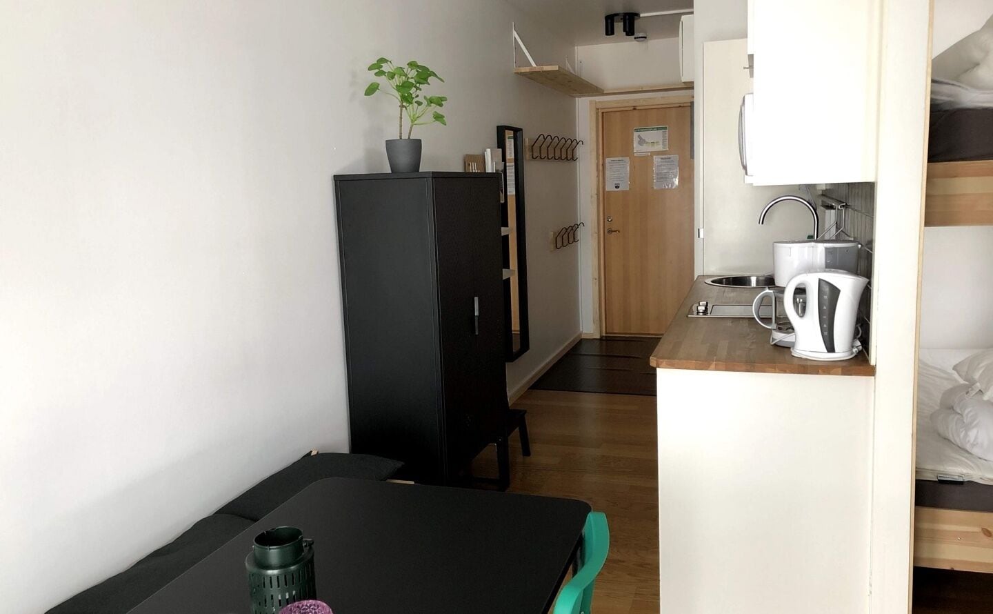 A compact room with a kitchenette, a dining area, and a small seating space.