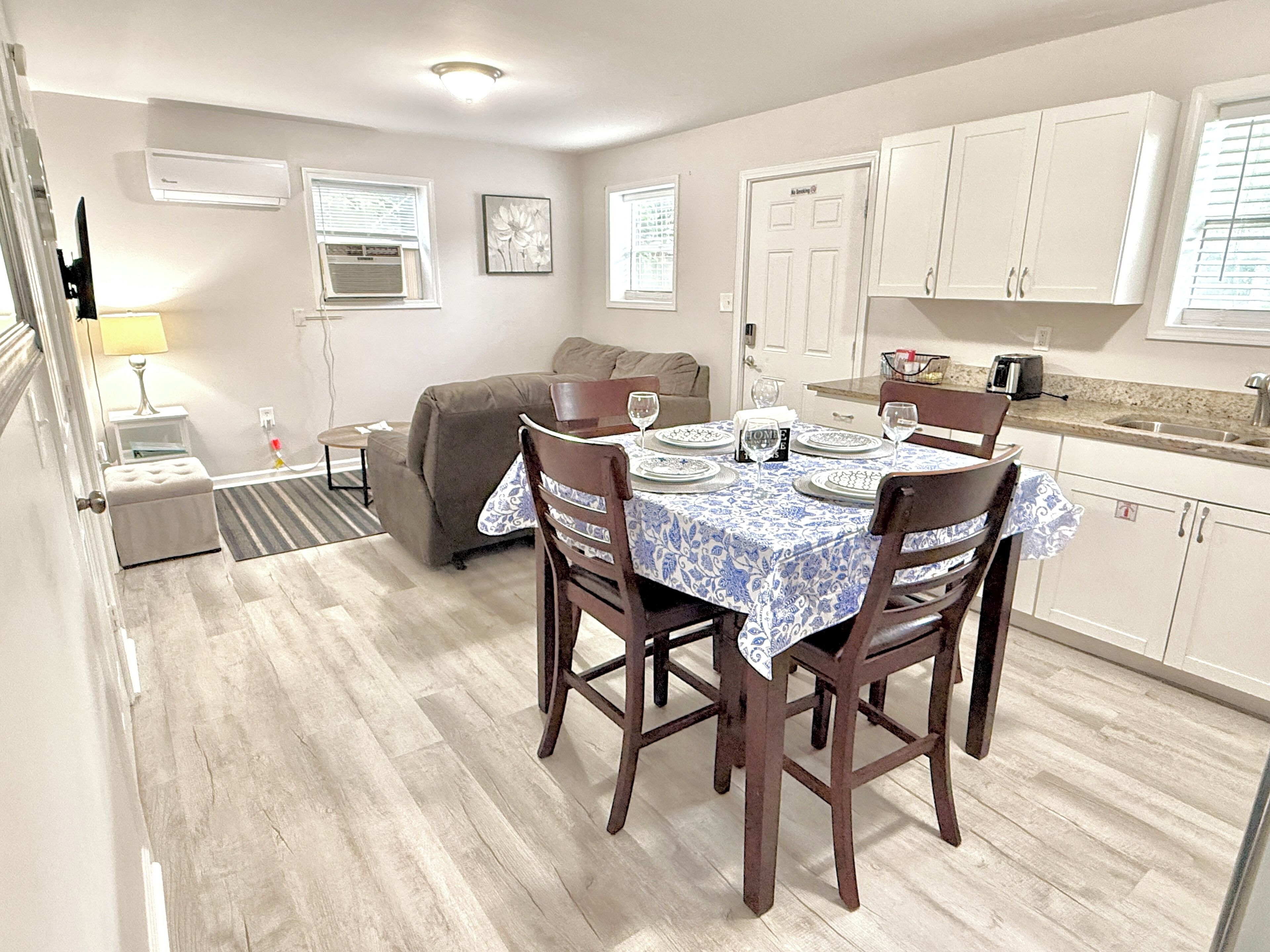 A compact living space with a dining area, kitchenette, and a sofa.
