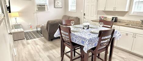 A compact living space with a dining area, kitchenette, and a sofa.
