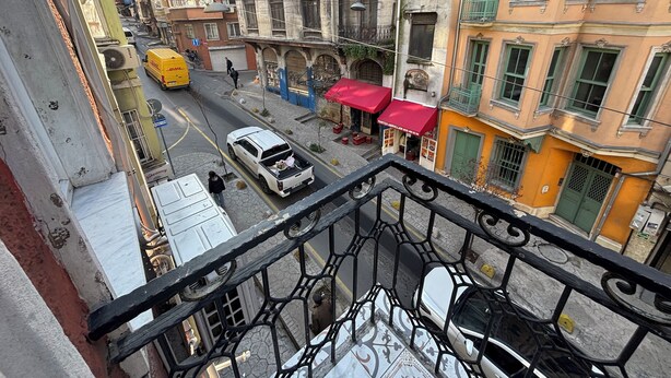 A street view from a balcony with buildings, a yellow DHL van, and a white pickup truck. - Istanberry - Scarlet Apartments (Istanbul)