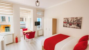 A bedroom with a bed, a desk, a chair, and a television. - Istanberry - Scarlet Apartments (Istanbul)
