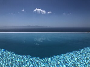 En tydlig vy över en swimmingpool med ett bergskedja i bakgrunden.