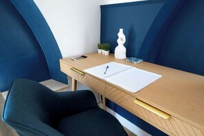 Un bureau moderne, avec un ordinateur portable, un stylo et quelques objets décoratifs.