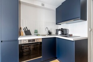 A modern kitchen with a dishwasher, oven, and a coffee maker.