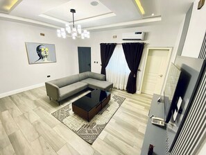 Appartement familial, balcon, vue sur la ville | Aire de séjour | Téléviseur à écran plat