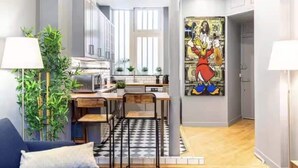 Et moderne køkken med spiseplads, et stort vindue og et mural på væggen.