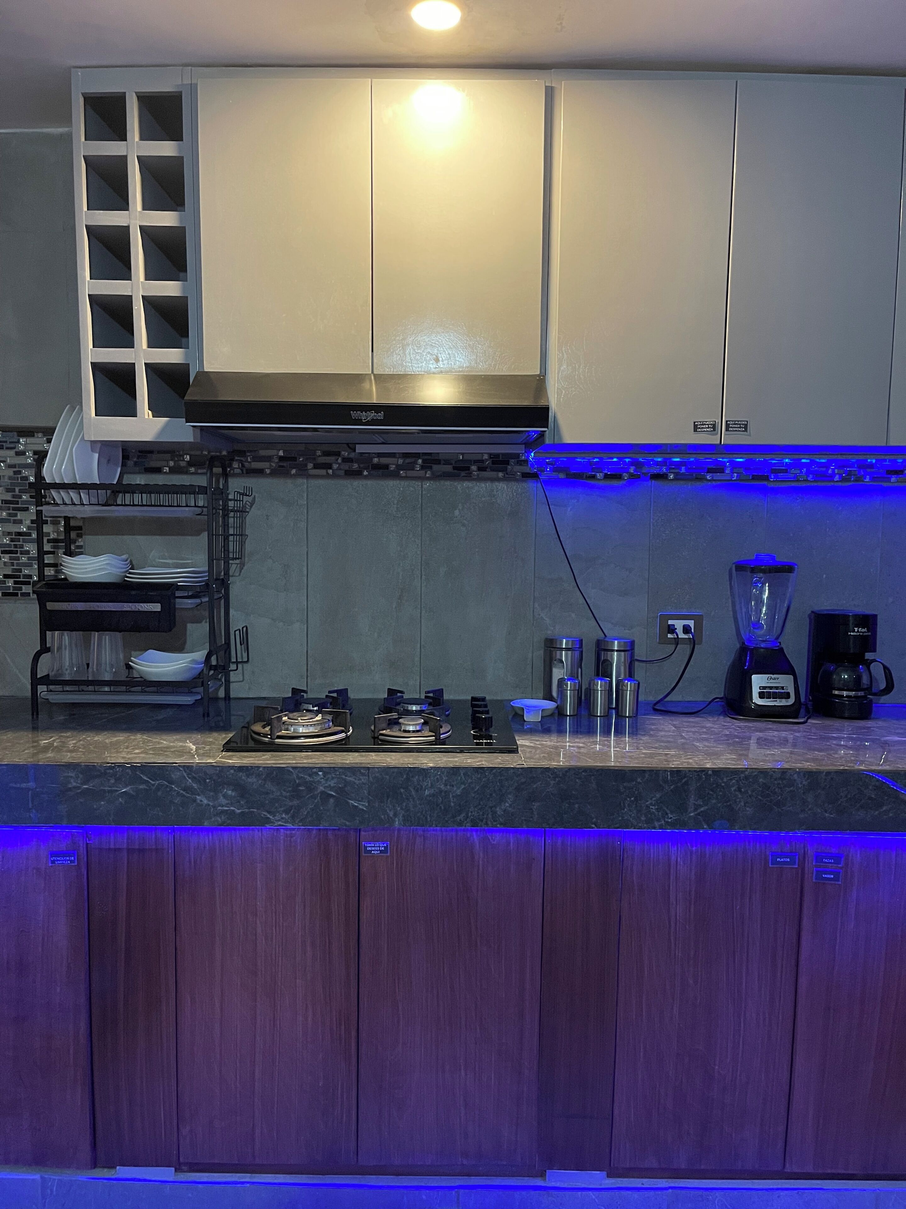 A modern kitchen with a gas stove, a coffee maker, and a blender.
