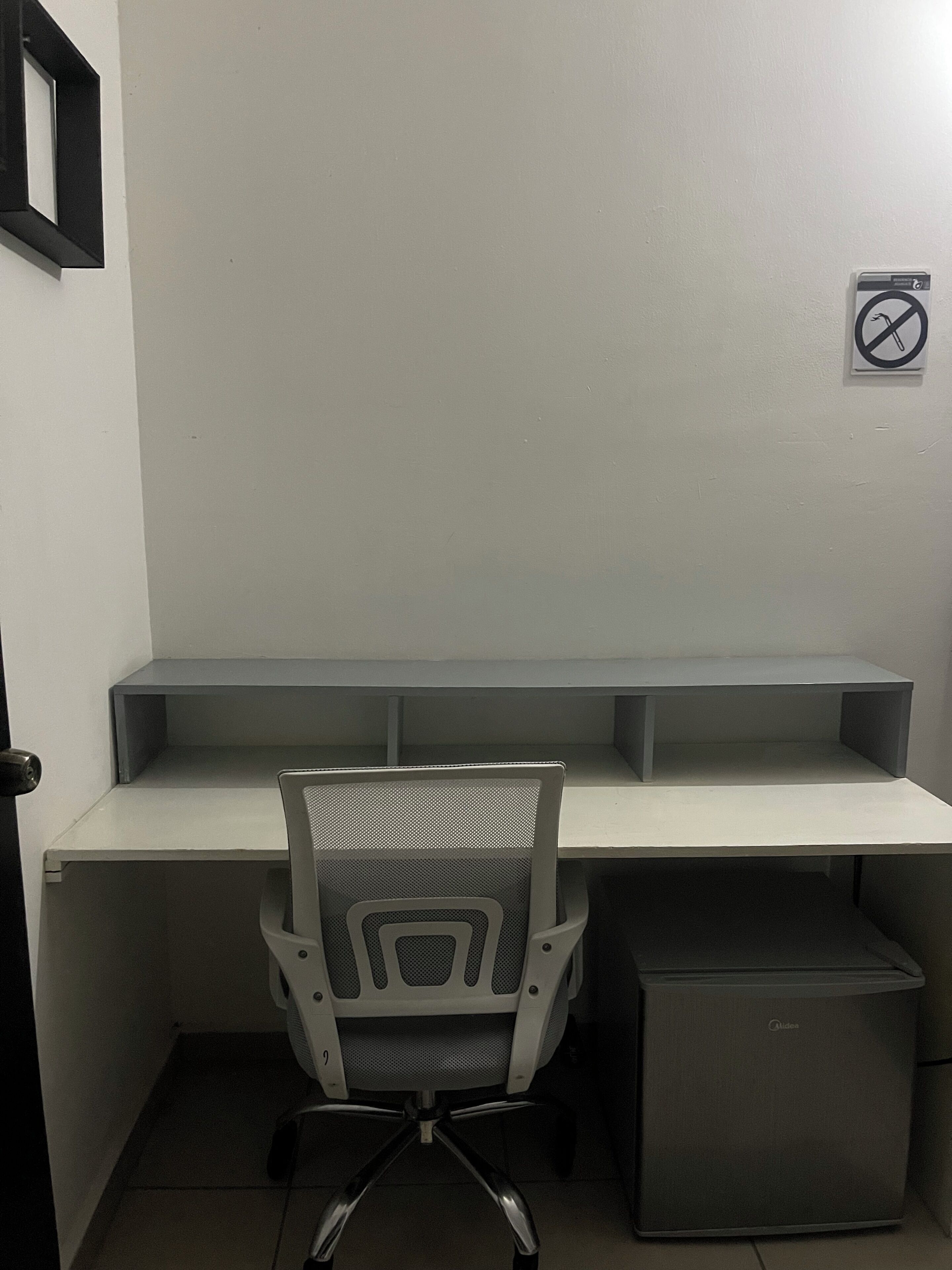 Un petit bureau comprenant un bureau, une chaise et un classeur.